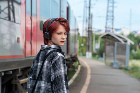 teenage girl with headphones at commuter train stationの写真素材