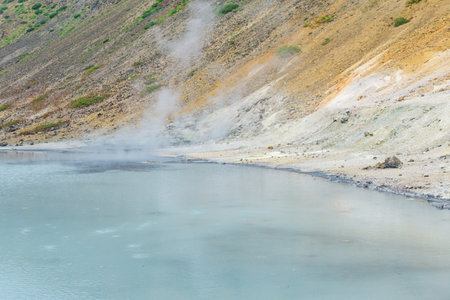 hot mineralized lake with thermal spring and smoking fumaroles in the caldera of the Golovnin volcano on the island of Kunashirの写真素材