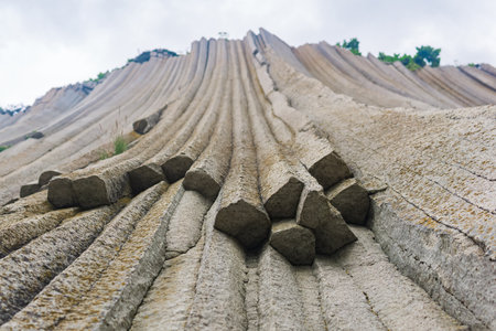 basalt columns forming a coastal rock at Cape Stolbchaty on Kunashir Island, close-upの写真素材