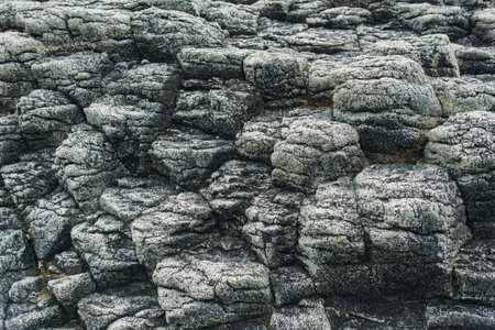 natural stone background, the remains of lava basalt columns form a relief surfaceの写真素材