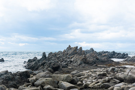 sharp jagged basalt rocks on the sea coast, Cape Stolbchaty on Kunashir Islandの写真素材