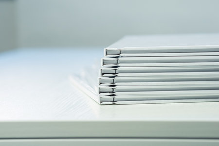 spines of photo books with clean empty white covers, close-up, partial blurの写真素材