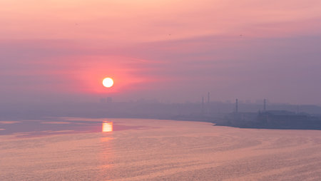 dawn landscape, morning sunrise over the river with cityscape on the shoreの写真素材