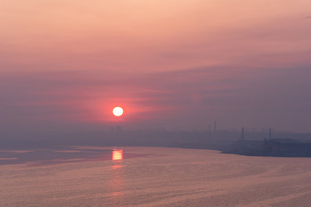 dawn landscape, morning sunrise over the river with cityscape on the shoreの写真素材
