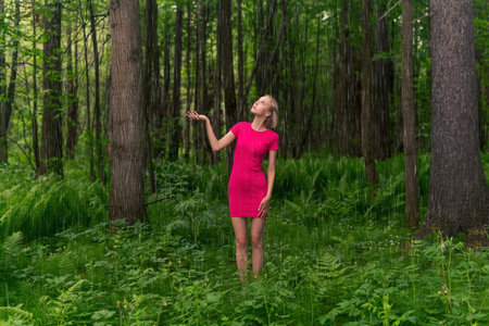 beautiful girl caught in the summer rain while walking in the forestの写真素材