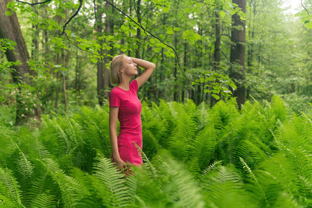 beautiful girl in the spring forest among the fernsの写真素材