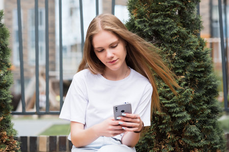 young woman with a phone on the background of cityscapeの写真素材