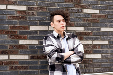 young man posing against a brick wallの写真素材