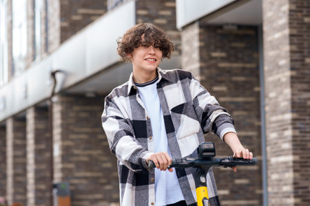 young man on an electric scooter rides down the streetの写真素材