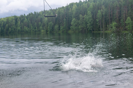 splash on the water - a bather dived into a forest lake from a makeshift tarzan swingの写真素材
