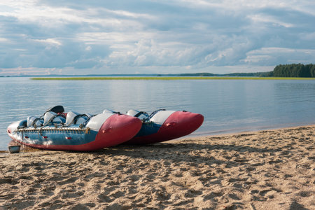 inflatable raft-catamaran for whitewater sports is moored on the river bankの写真素材