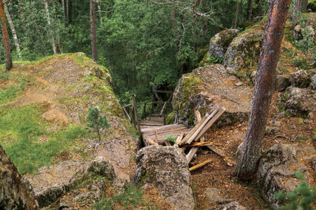 ruined wooden staircase on an abandoned path in a mountain forestの写真素材