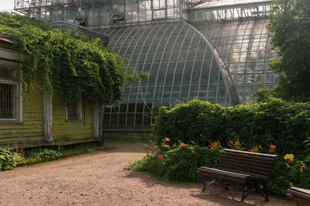 corner of an old botanical garden with a huge vintage greenhouse in the backgroundの写真素材