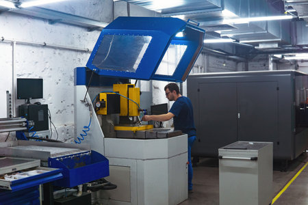 Perm, Russia - July 13, 2023: worker in the workshop regulates the operation of a metalworking machineのeditorial素材