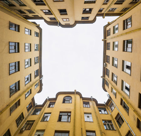 narrow and deep courtyard-well formed by closely standing walls of housesの写真素材