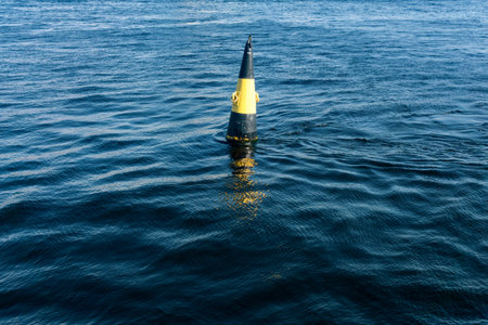 A view of a buoy in the river on a sunny day, east cardinal mark of dangerの写真素材