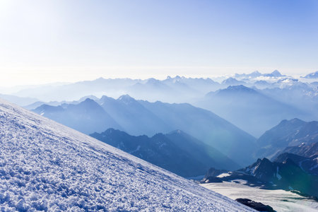 view from highland glacier to misty mountains in the rays of dawn