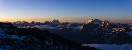 mountain peaks in the rays of early morning dawn, panoramic natural landscapeの写真素材