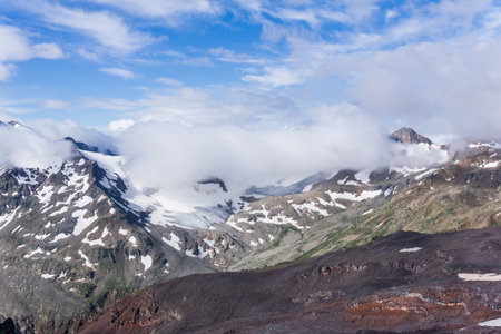 high mountainous landscape of Caucasus, peaks and glaciers among cloudsの写真素材