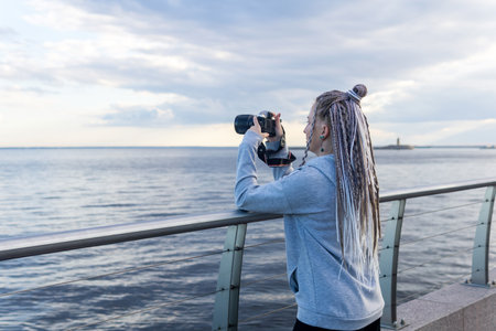 female tourist takes photo on embankmentの写真素材