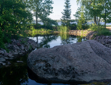 shady decorative pond with stone banks in the parkの写真素材