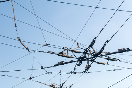 industrial urban background, intertwining cables over the street at the intersection of trolleybus contact wiresの写真素材