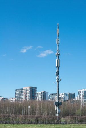 Telecommunication tower on a background of city and blue sky