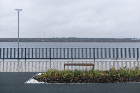 Bench on the embankment of the lake in cloudy weather.の写真素材