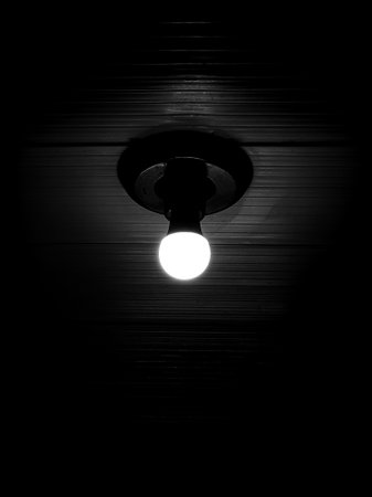 Black and white light bulb in a dark room. Abstract background.の写真素材