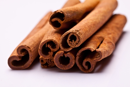 cinnamon sticks stacked on white background の写真素材