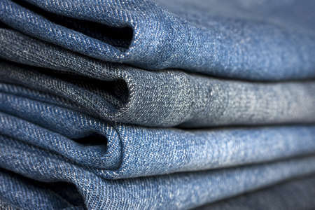 A pile of different types of blue denim jeans closeupの写真素材