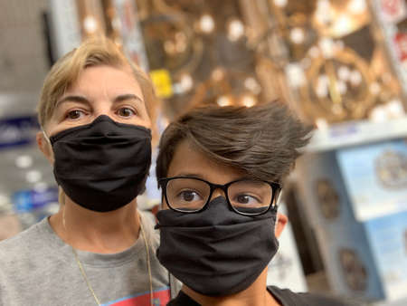 woman and boy wearing  black masks in a middle of a store in Spanish Fork Utah