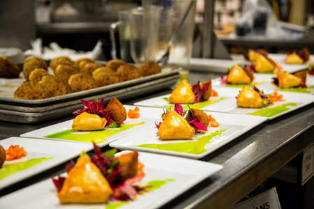 Brazilian food inside of a restaurant's kitchen, plated up service, esfiha, coxinha, steak, fried...