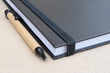 Notebook and pen laying on cotton.