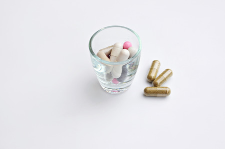 herbal drug, colorful medicines in glass on white 