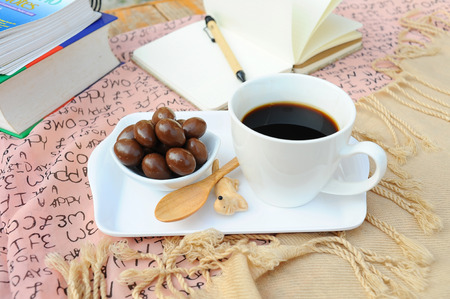 hot coffee in cup,chocolate and note on tableの写真素材