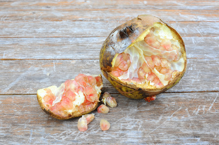 Rotting pomegranates fruit on wooden backgroundの写真素材