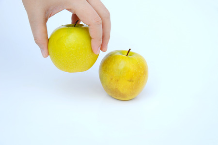 hand holding a dried green apple on white backgroundの写真素材