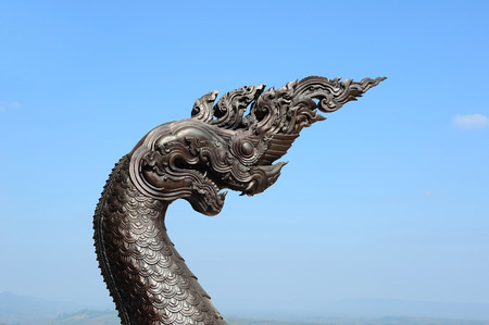 naka statue in front of Thai Buddhist pagoda on background blue skyの写真素材