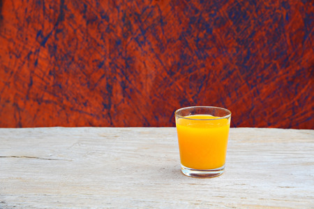 orange juice in glass on wooden backgroundの写真素材