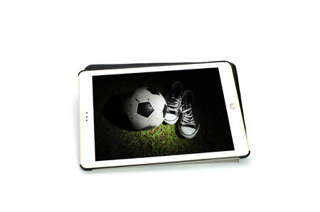 Sneakers with a soccer ball in tablet on white backgroundの写真素材