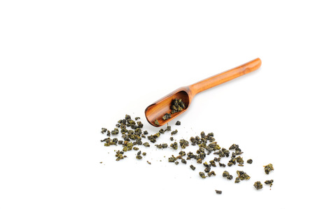 dried tea leaves out of wooden spoon