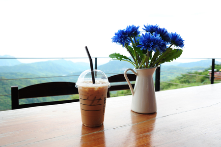 iced coffee on wood table and nature background (Style Still Life)