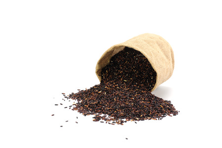 riceberry or oganicrice pouring out of  Gunny bag on white backgroundの写真素材