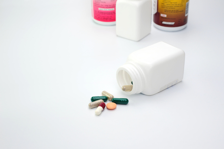 medicine or pills (capsule) was poured out of bottle on white backgroundの写真素材
