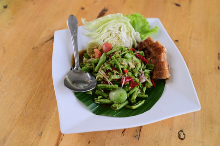 Thai spicy salad with pork and vegetable on wooden background, Thailand.の写真素材