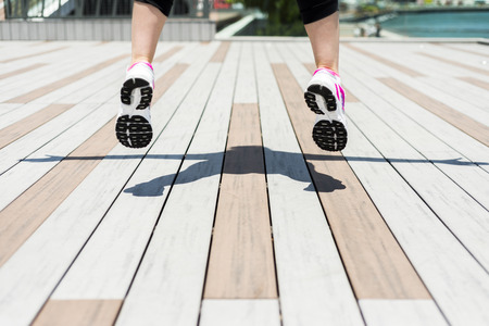 a Woman jumping while stretching her arms in a streetの写真素材