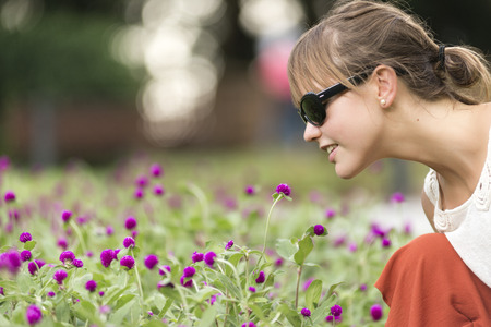 Cute Girl smelling a flower in the public Zoo in Hong Kongの写真素材