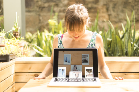 Girl looking at her new fancy self-portrait in a Cafeteria of Hong Kong Islandの写真素材