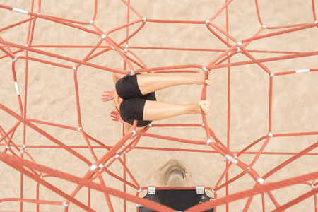Face down and holding with her Foot on a red Rope